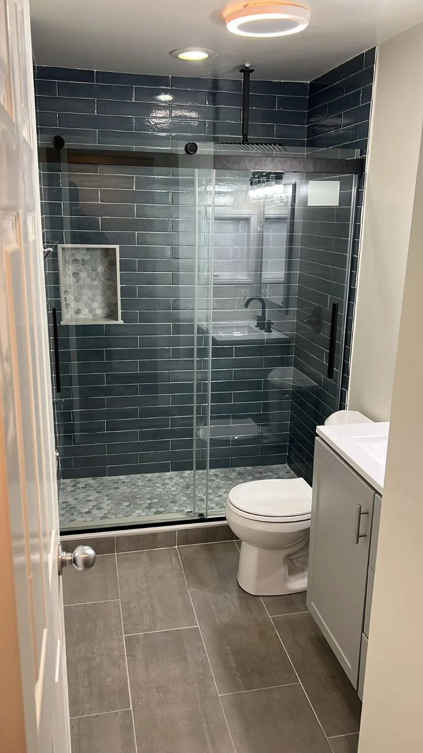 Blue tile walk-in shower with glass door