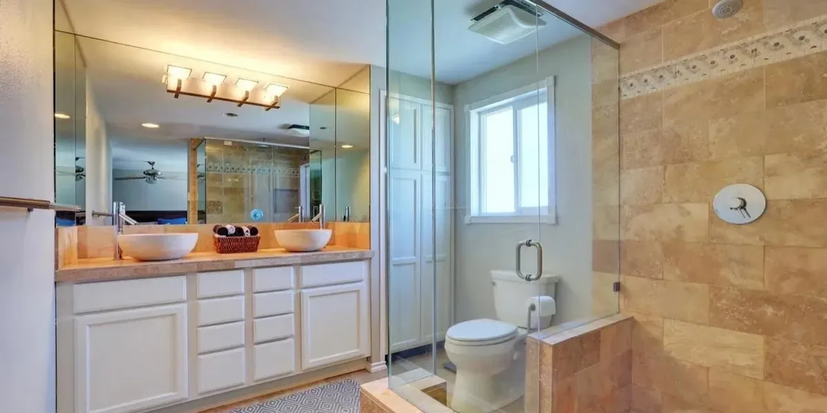 Tan tile bathroom with double sinks