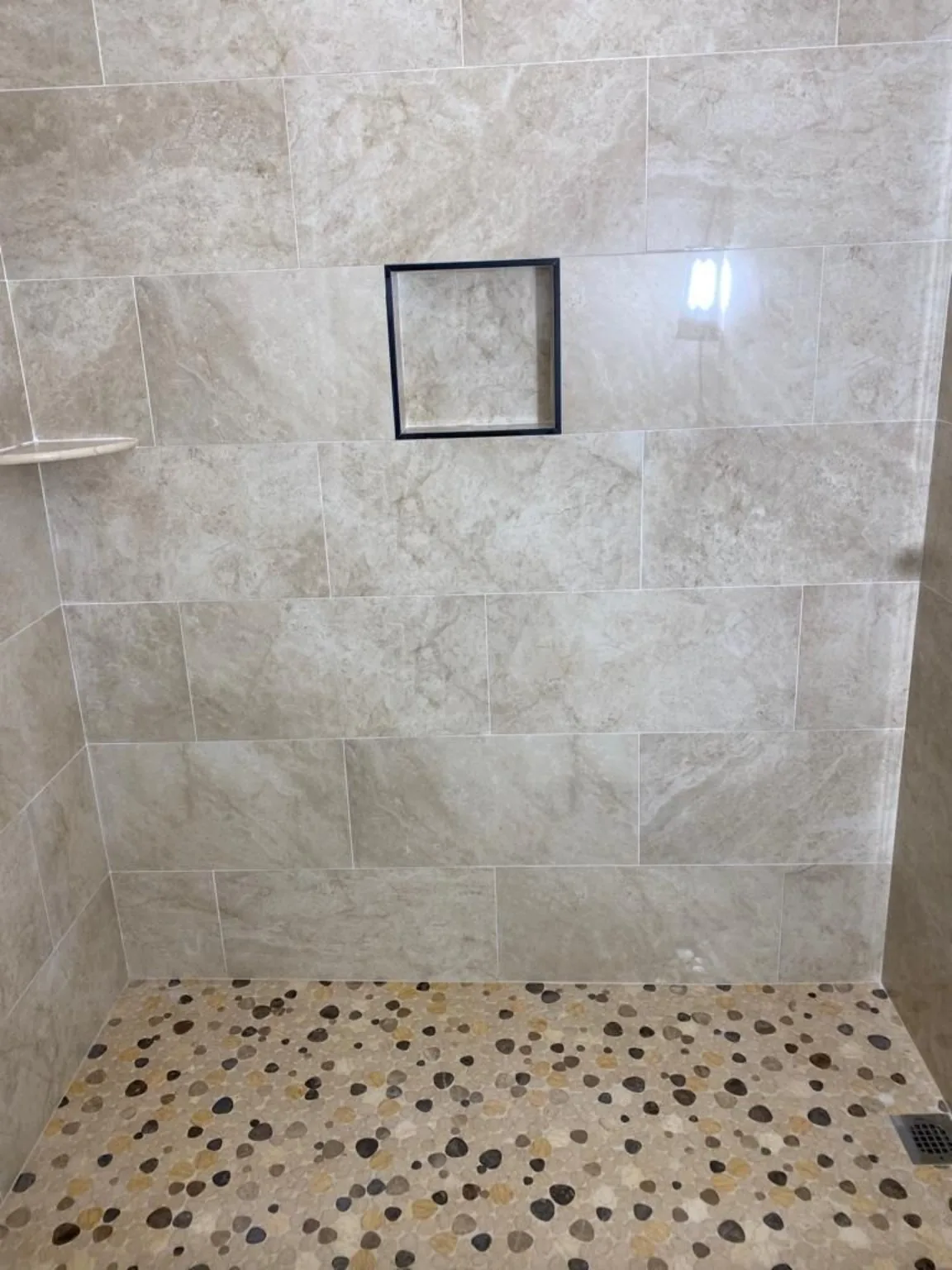 Shower with pebble floor and niche